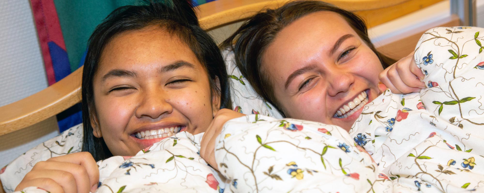Bilde av to jenter som ligger i en seng og ler sammen - Kristen Videregående Skole Nordland - E-sport