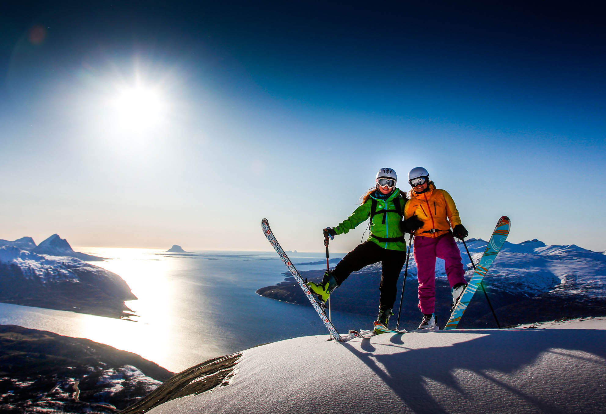 Bilde av to elever, jenter, som står på ski på vinteren, de smiler og ser ut til å ha det veldig gøy. De er på snødekt fjell med sol og blå himmel i bakgrunnen - Kristen Videregående Skole Nordland - E-sport