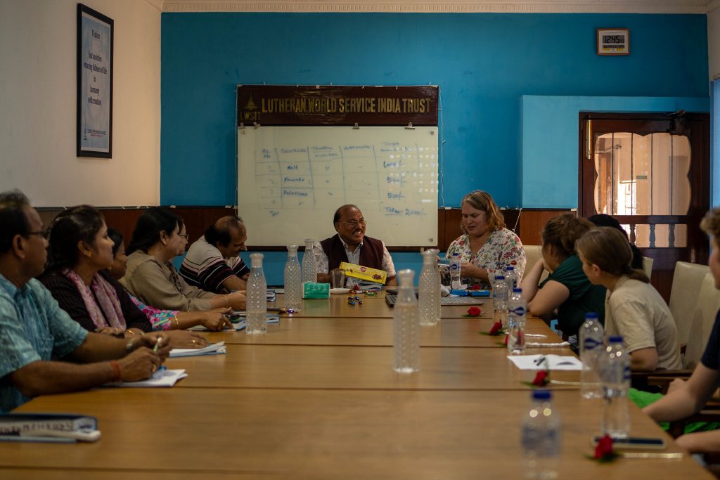 Flere personer som sitter i et konferanserom og prater