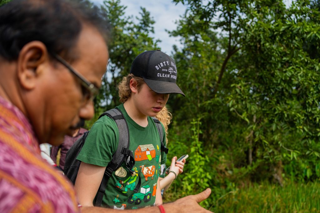 Bilde av elev som snakker med en prosjektleder mens de ser på jordbruket