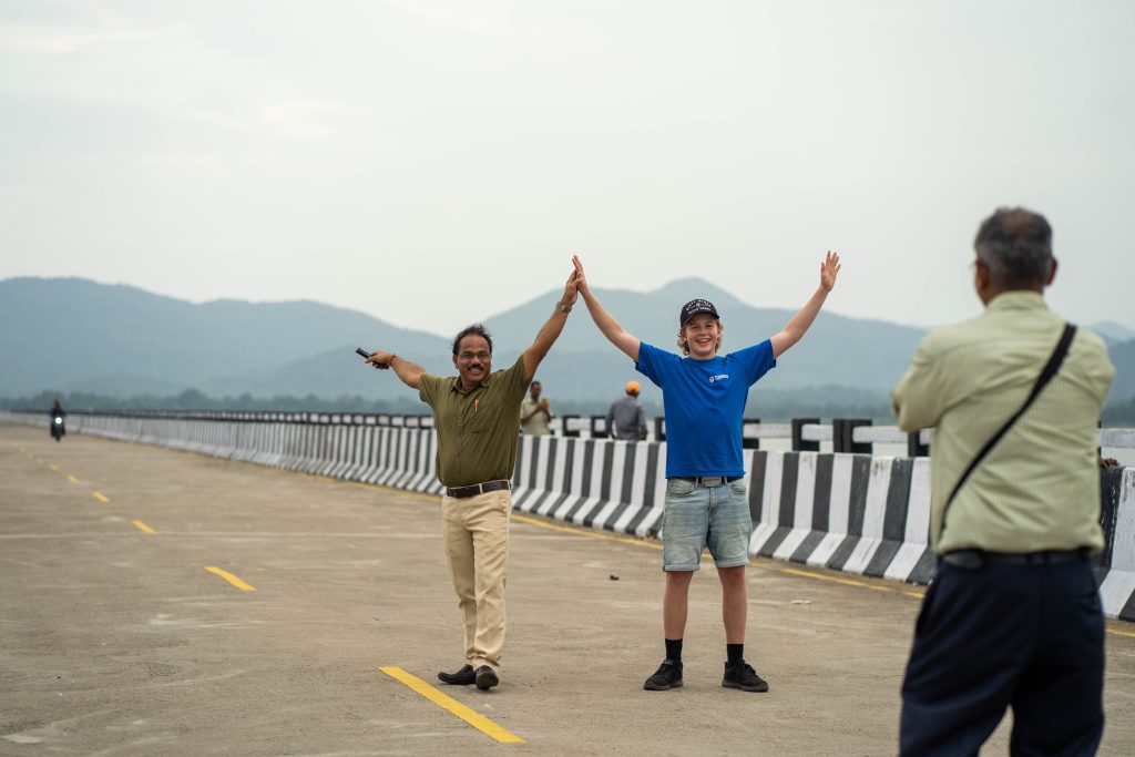 Bilde av to personer som holder hendene opp mens de står på en bru