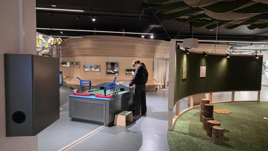 En elev står ved et arbeidsbord og leker med leker.