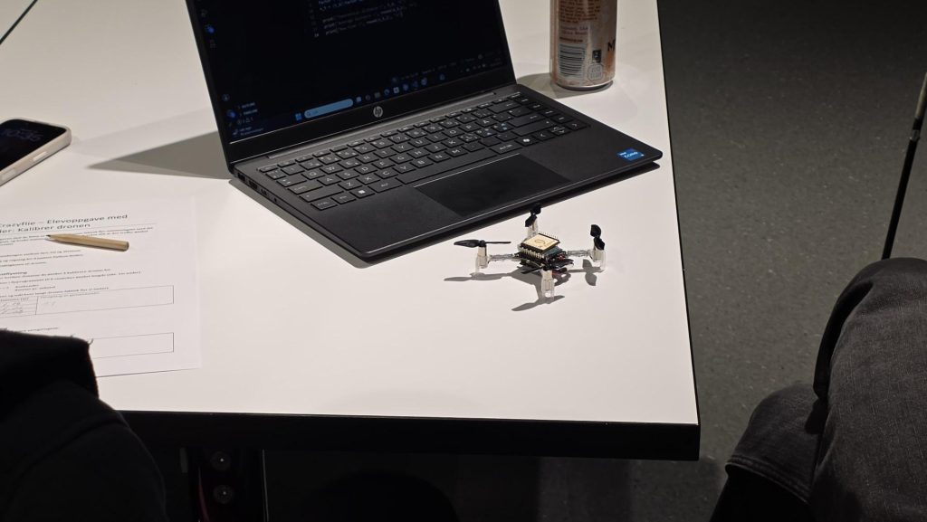 En mini-drone som ligger ved en bærbardatamaskin