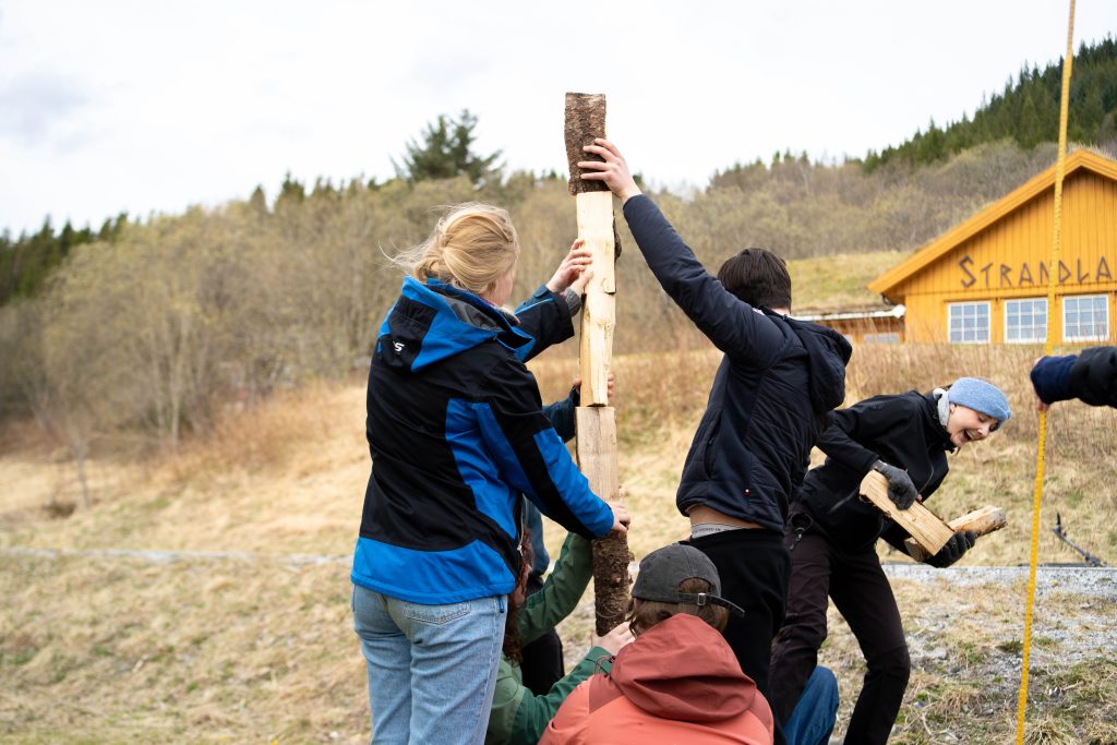 Elever som legger vedkubber oppå hverandre for å bygge tårn