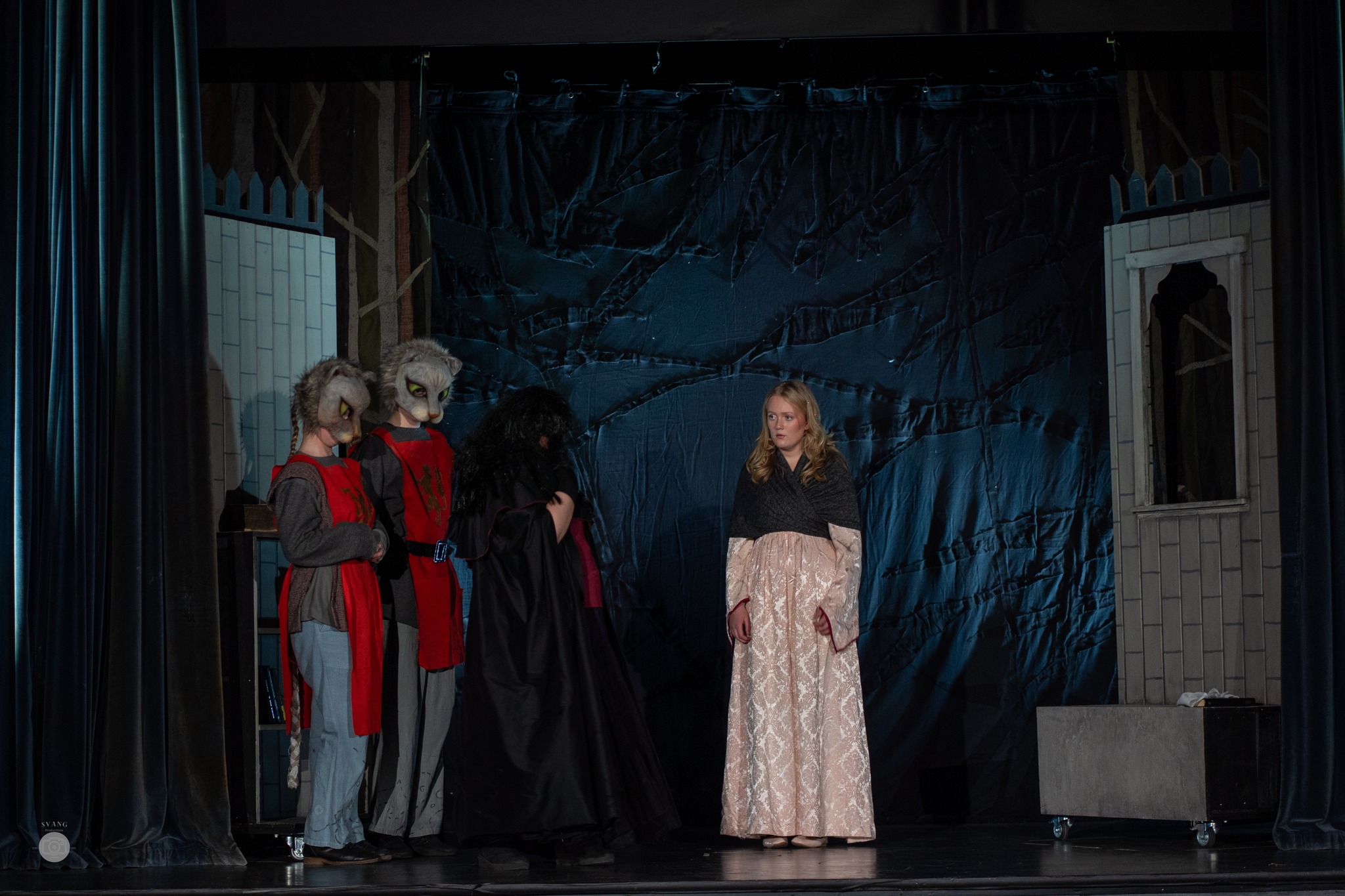 To personer i kattemasker, pluss en dame kledd som en heks og en som fattig prinsesse står oppe på en scene