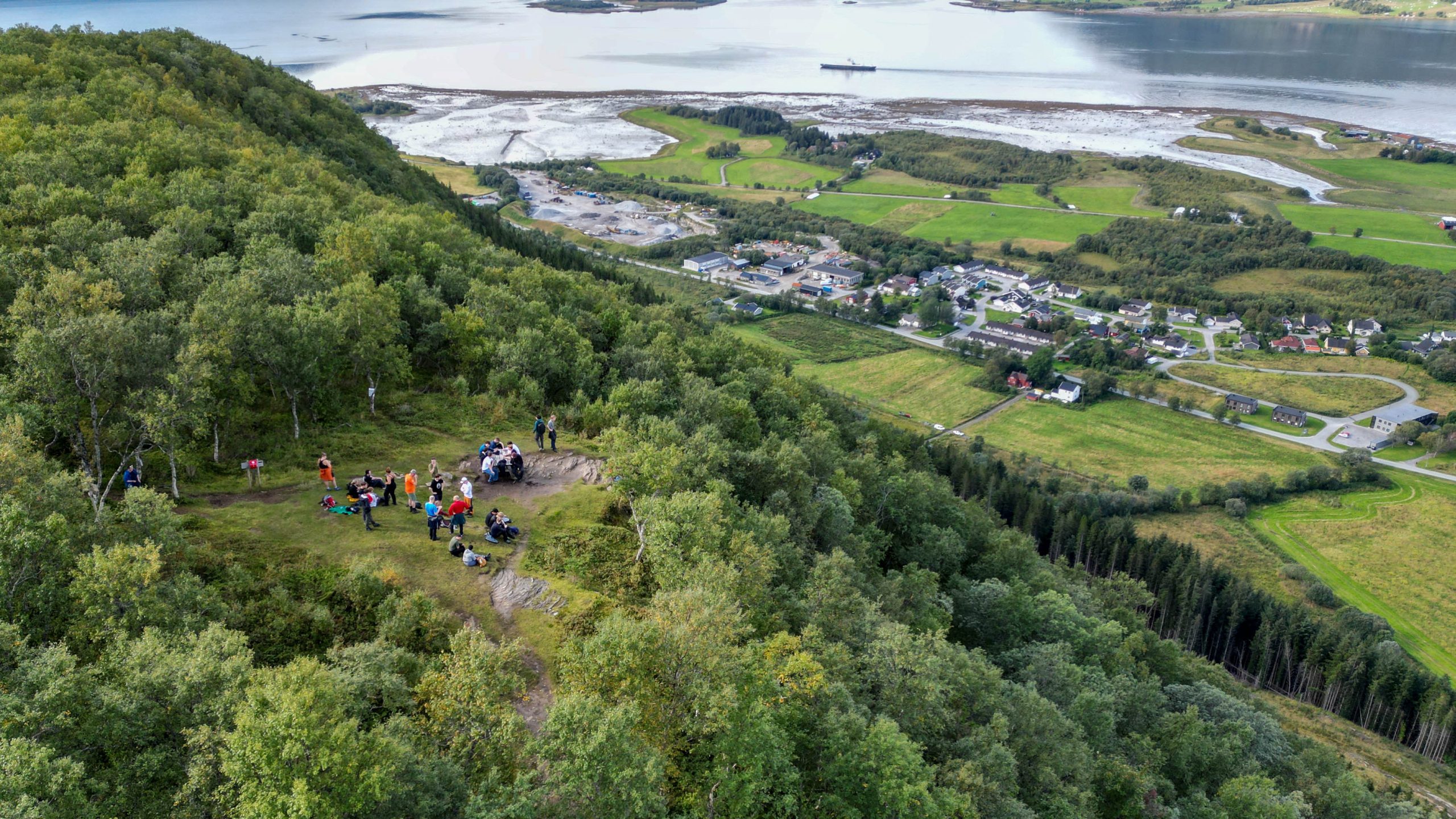 Dronebilde av en gruppe mennesker på en fjelltopp tatt fra oven.